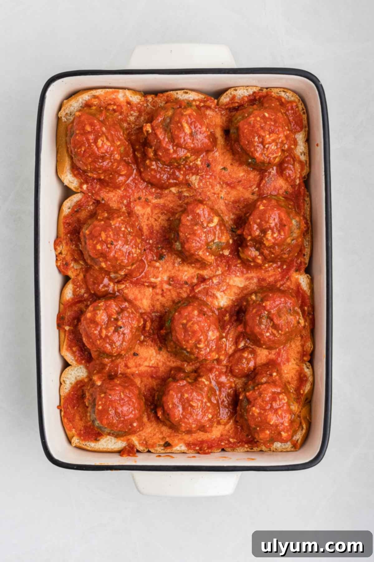 Meatballs in marinara arranged over the bottom half of the rolls.