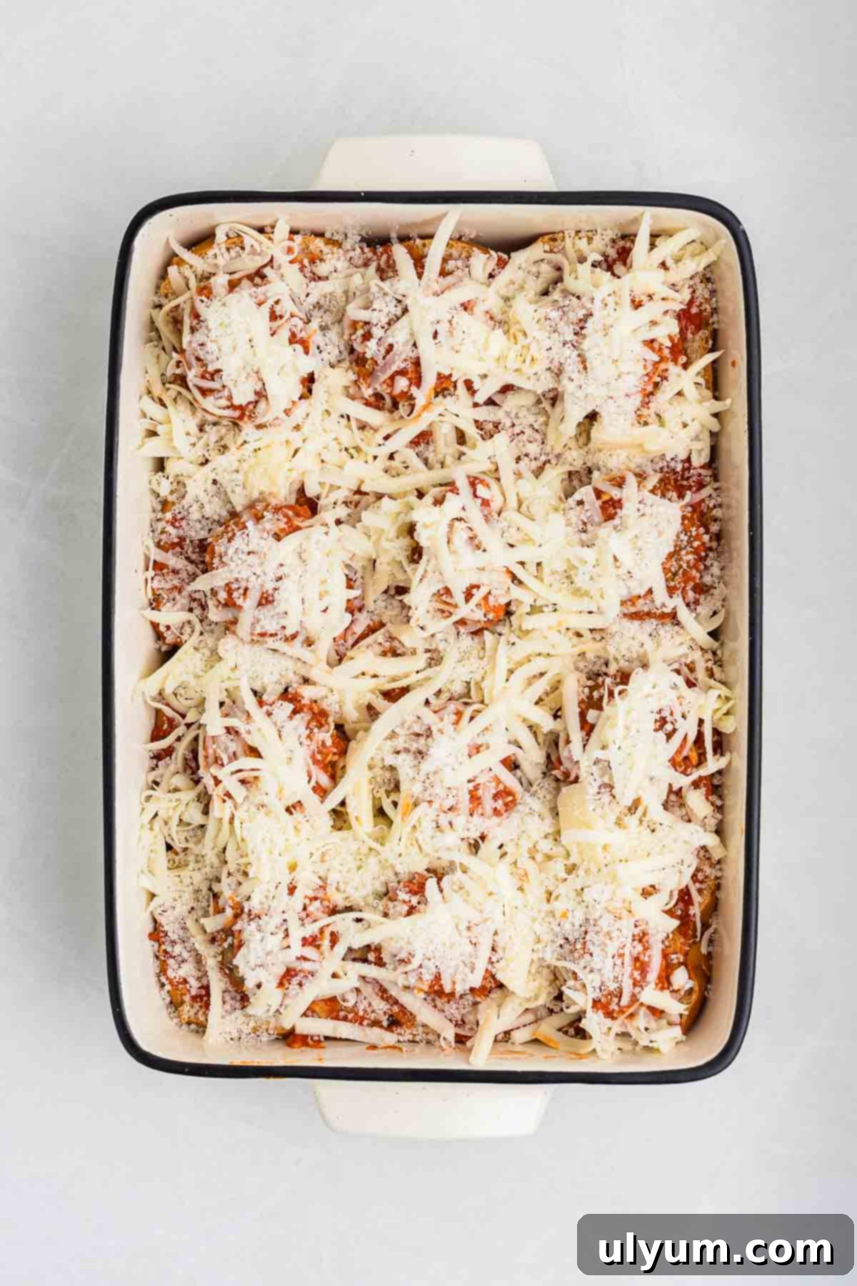 A baking dish with meatballs topped with shredded mozzarella.