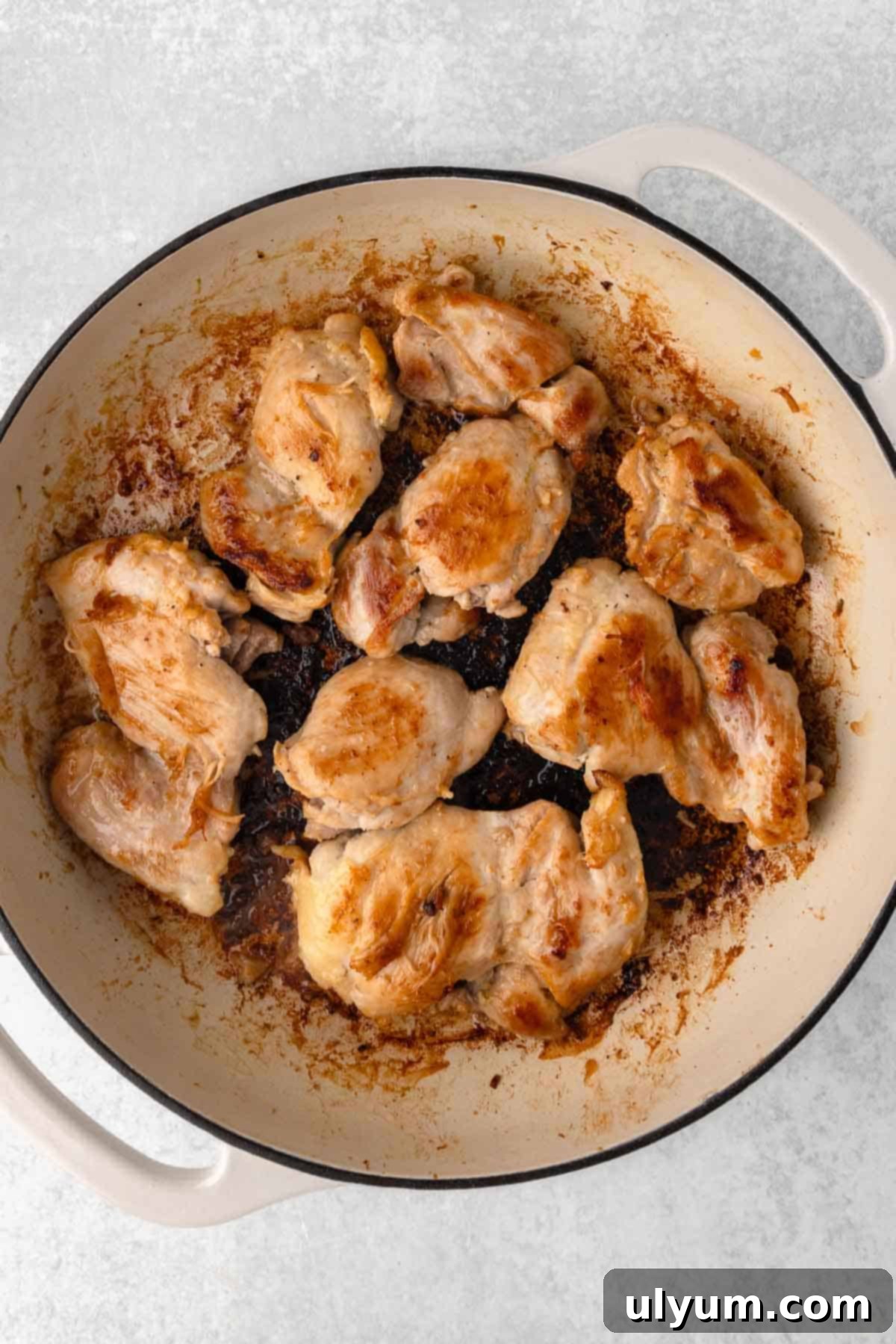 Easy One Pan Coconut Lime Chicken 7 Chicken thighs browning in a pan with dark seared spots.