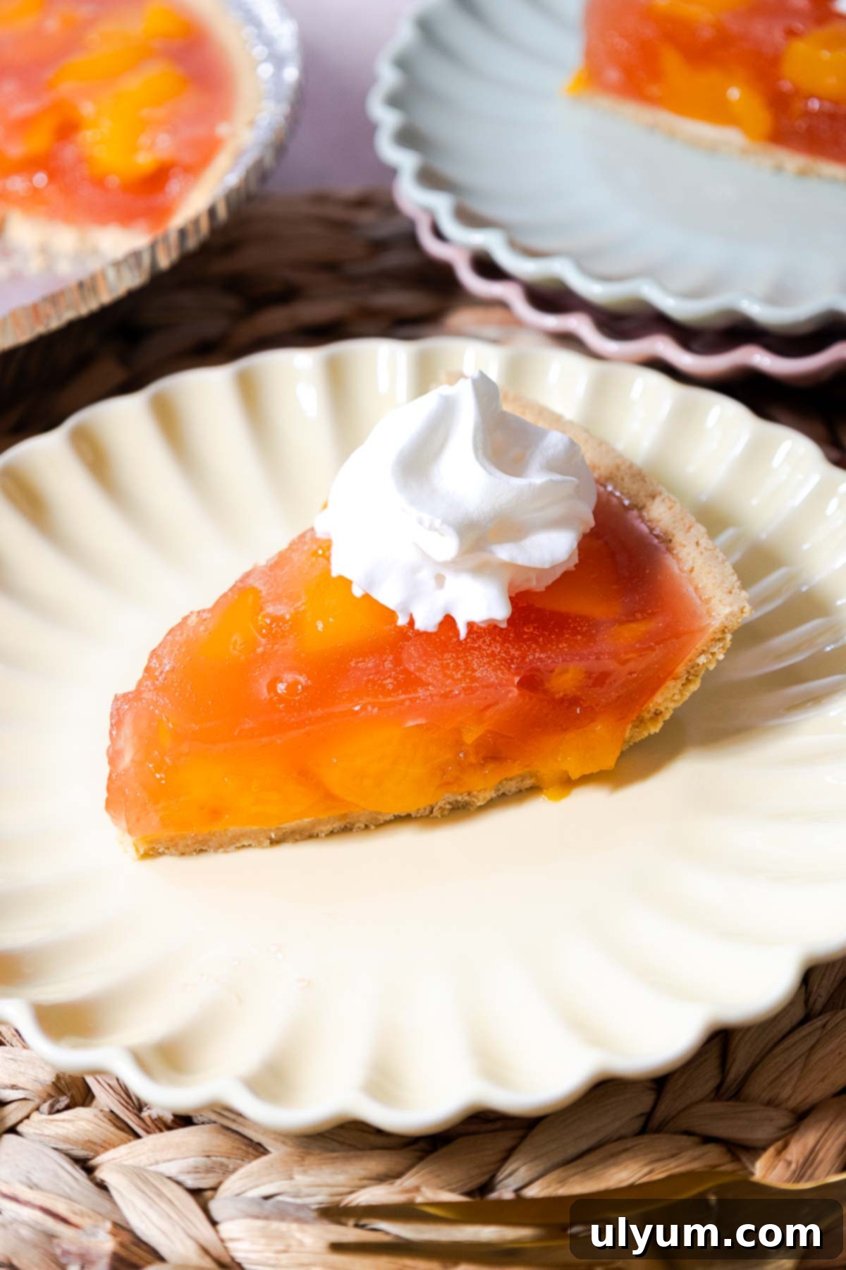 A slice of peach Jello pie topped with whipped topping, ready to be enjoyed.