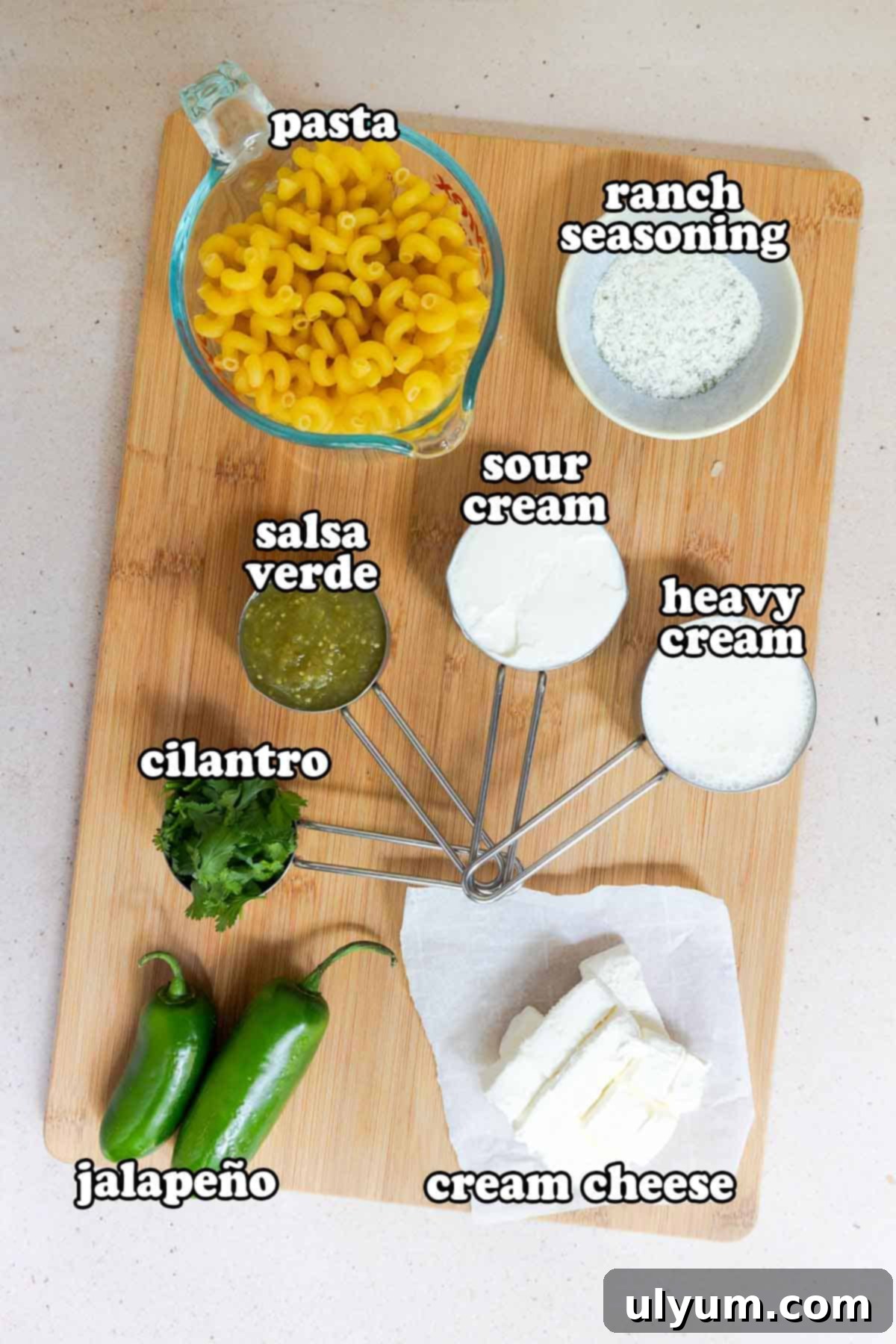 Spicy Creamy Jalapeño Ranch Pasta 3 Ingredients on a board: dry pasta, ranch seasoning, sour cream, heavy cream, salsa verde, cilantro, jalapeños, and cream cheese.