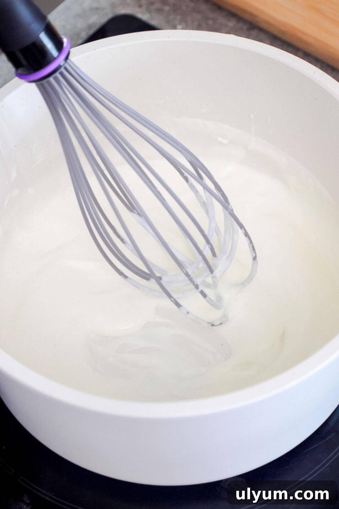 Spicy Creamy Jalapeño Ranch Pasta 6 A whisk in a saucepan of white cream mixture.