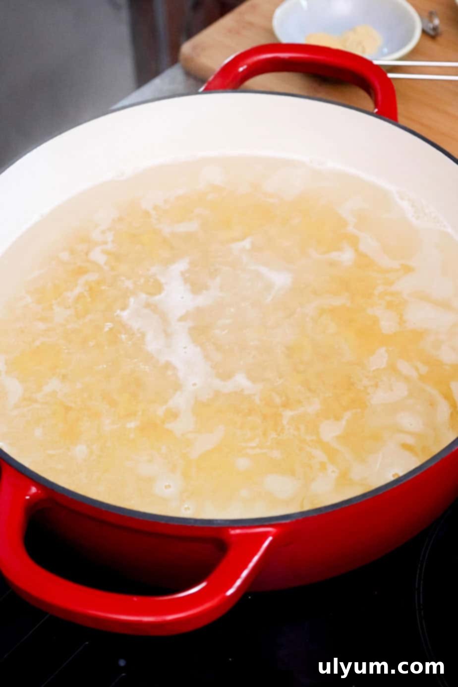 Elbow macaroni boiling vigorously in a large pot of salted water, preparing for the creamy cheese sauce.