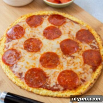Cottage cheese pizza crust topping with shredded mozzarella and pepperoni.