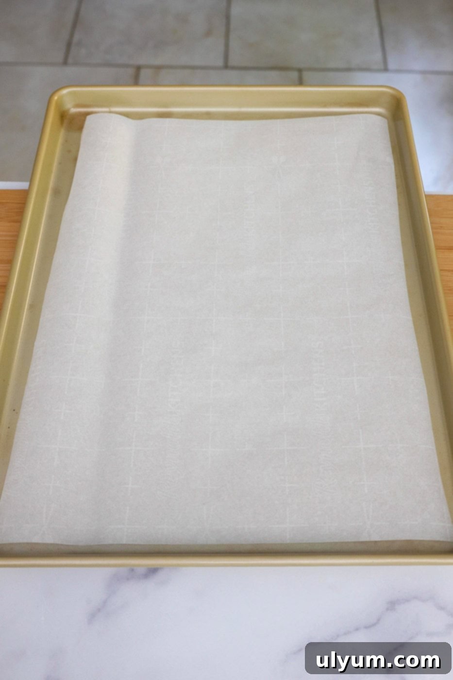 A baking sheet lined with parchment paper, prepared for the pizza crust.