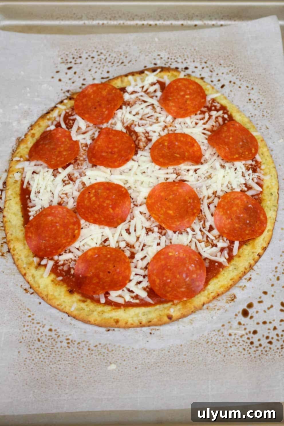 An unbaked cottage cheese pizza, topped with a generous layer of pizza sauce, shredded mozzarella cheese, and turkey pepperoni slices.