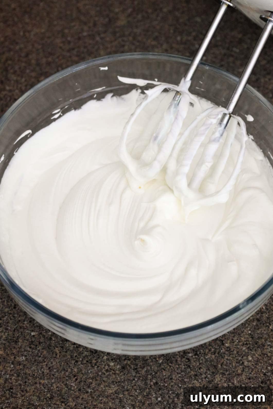 Final whipped fruit dip in a bowl with a fluffy and airy consistency, beaters from an electric mixer resting above it.