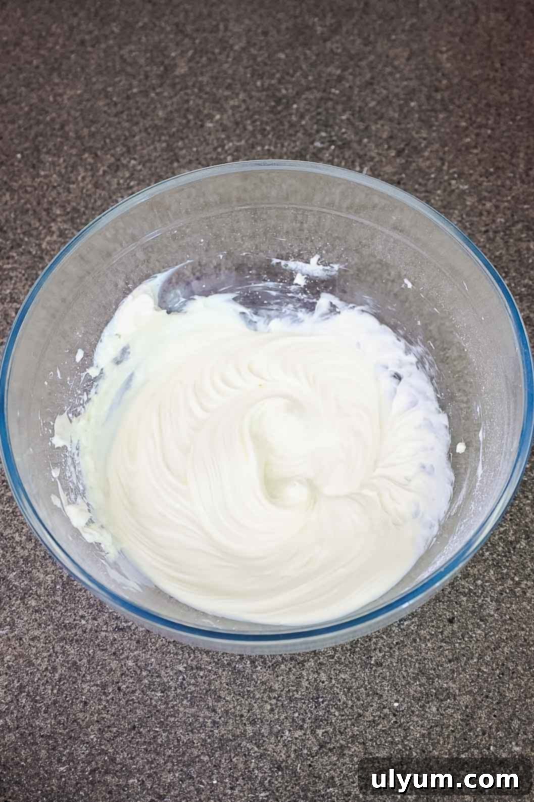 Mixture in a glass bowl after powdered sugar and vanilla are blended into whipped cream cheese.