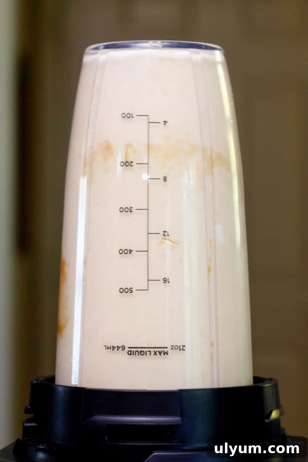 A creamy peanut butter smoothie being blended in a bullet-style blender cup.