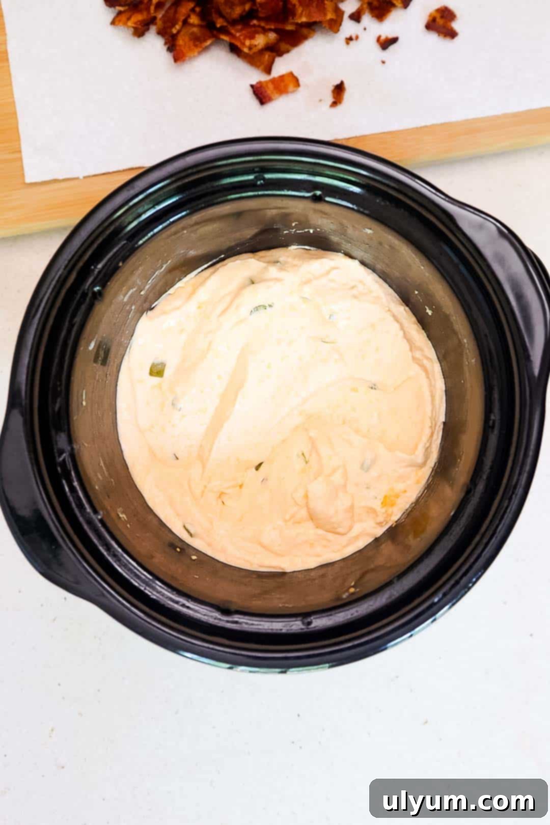 Smooth, creamy jalapeño popper dip inside a slow cooker.