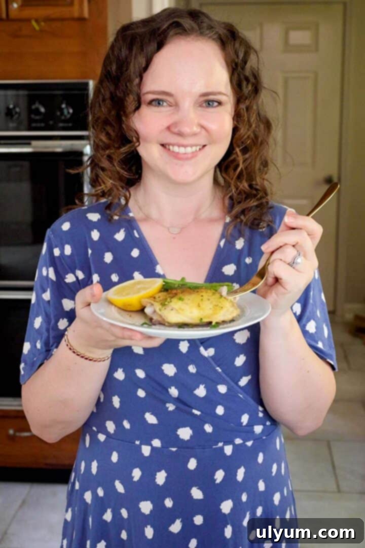 Golden Lemon Pepper Chicken Thighs 10 Kelsey Smith holding a plate of lemon pepper chicken thighs.