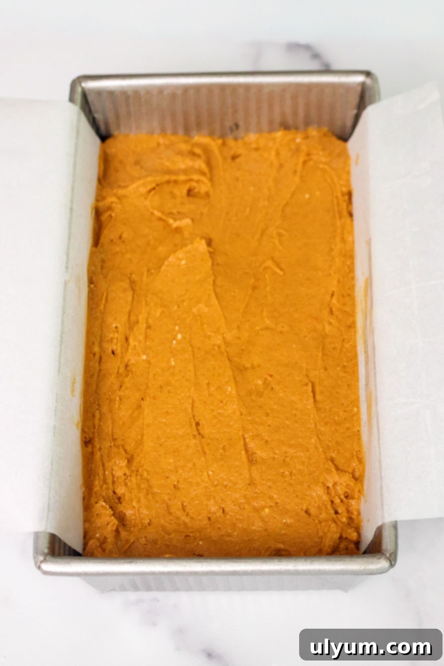 Pumpkin Spice Cake Loaf 6 Pumpkin bread batter smoothed into a parchment-lined loaf pan, ready to bake.