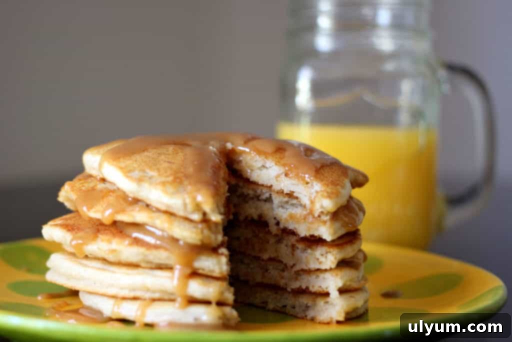 A stack of golden Bisquick banana pancakes, with a slice already taken out, ready to be enjoyed.