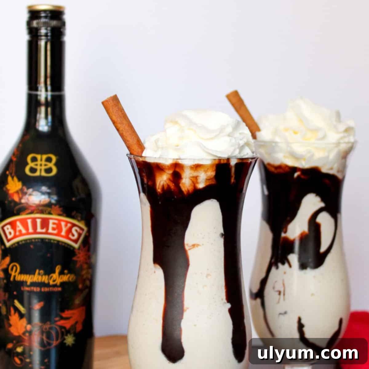 Delicious Frozen Pumpkin Spice Mudslide topped with whipped cream and a cinnamon stick, ready to be enjoyed.