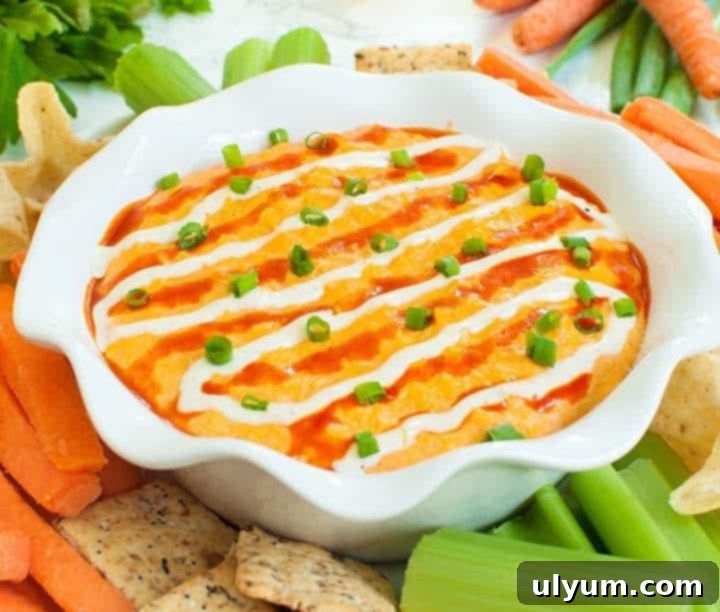 Score Big: 48 Instant Pot & Slow Cooker Game Day Eats 3 Slow Cooker Buffalo Chicken Dip, a creamy and flavorful dip served with celery sticks.