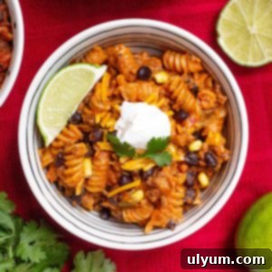 Instant Pot Beef Taco Pasta topped with a dollop of sour cream and a lime wedge.