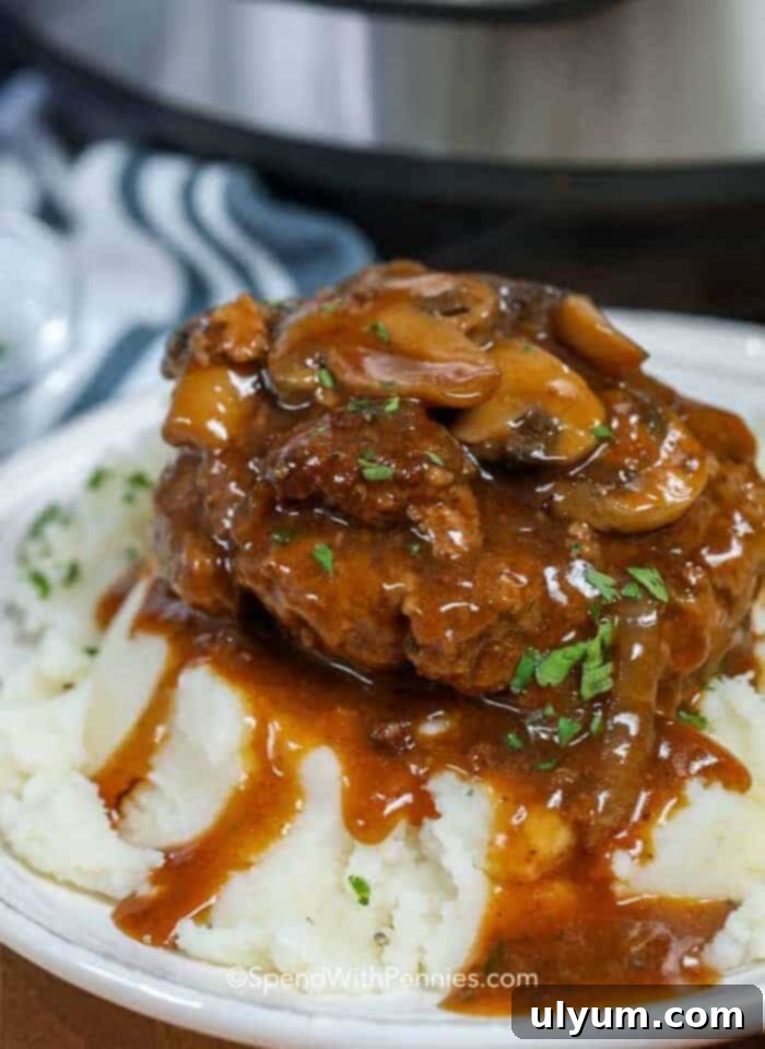 Instant Pot Salisbury Steak with mushroom gravy served over mashed potatoes.