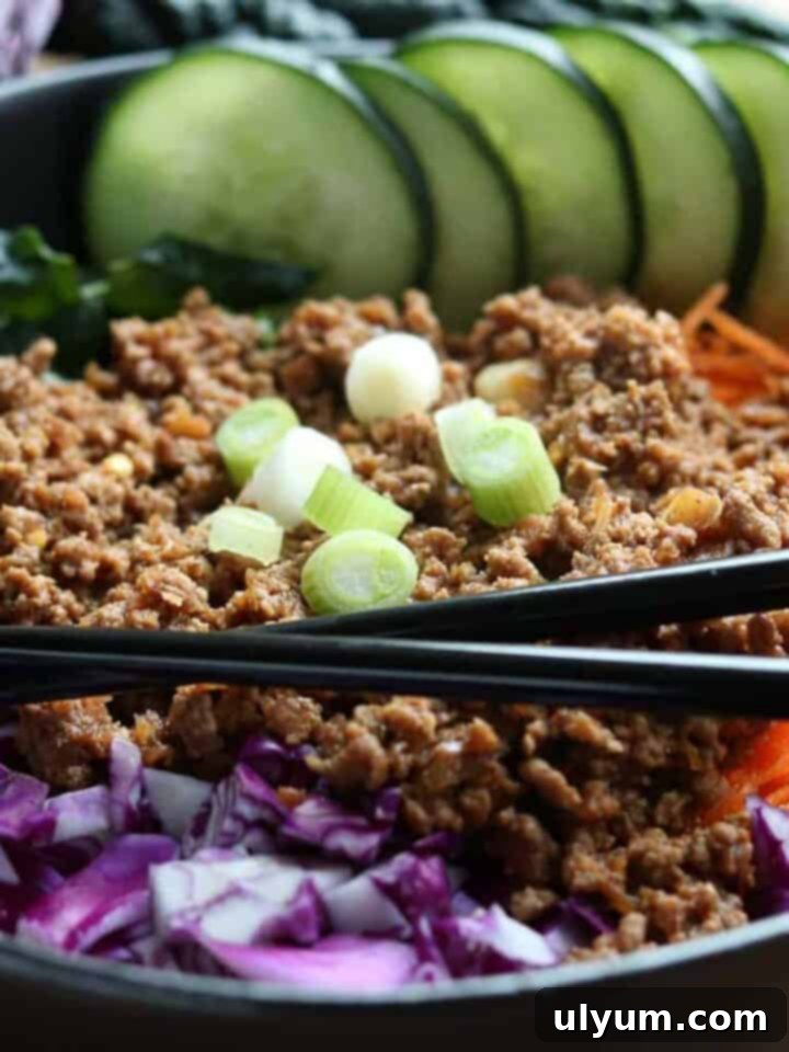 Healthy Instant Pot Korean Beef served over shredded kale, carrots, and cabbage, garnished with green onions.