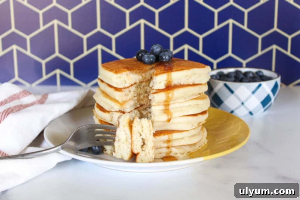 Stack of pancakes with a slice taken out.