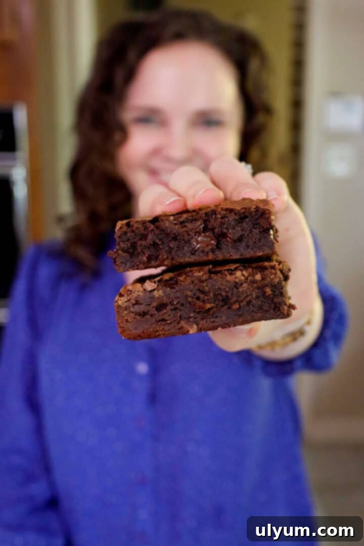 Kelsey Smith holding two brownies stacked together toward the camera.