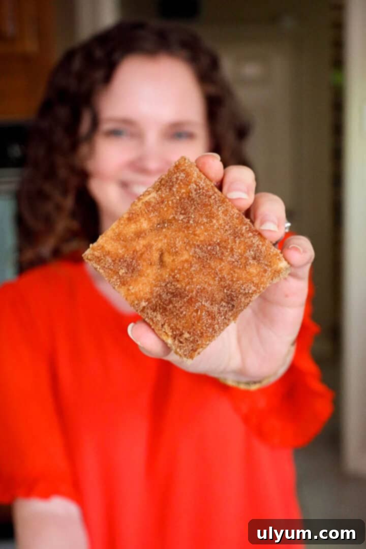 Kelsey Smith holding a snickerdoodle cookie bar toward the camera.