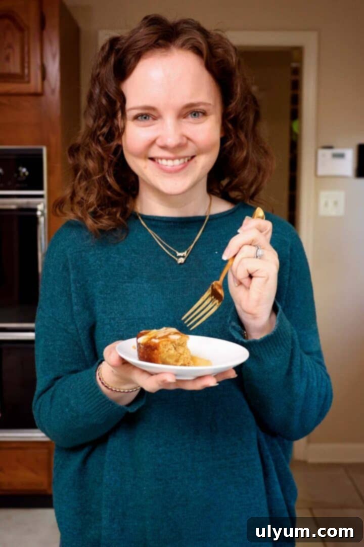 Kelsey Smith holding a plate of apple cake with a fork in hand.