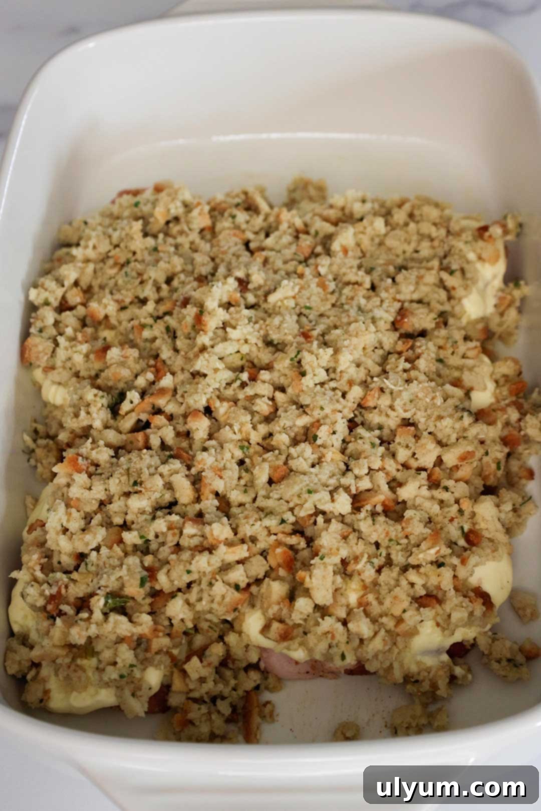 Baking dish with pork chops covered in stuffing.