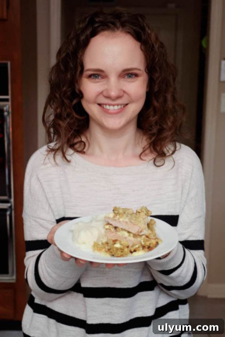 Kelsey Smith holding a plate of pork chops and stuffing.
