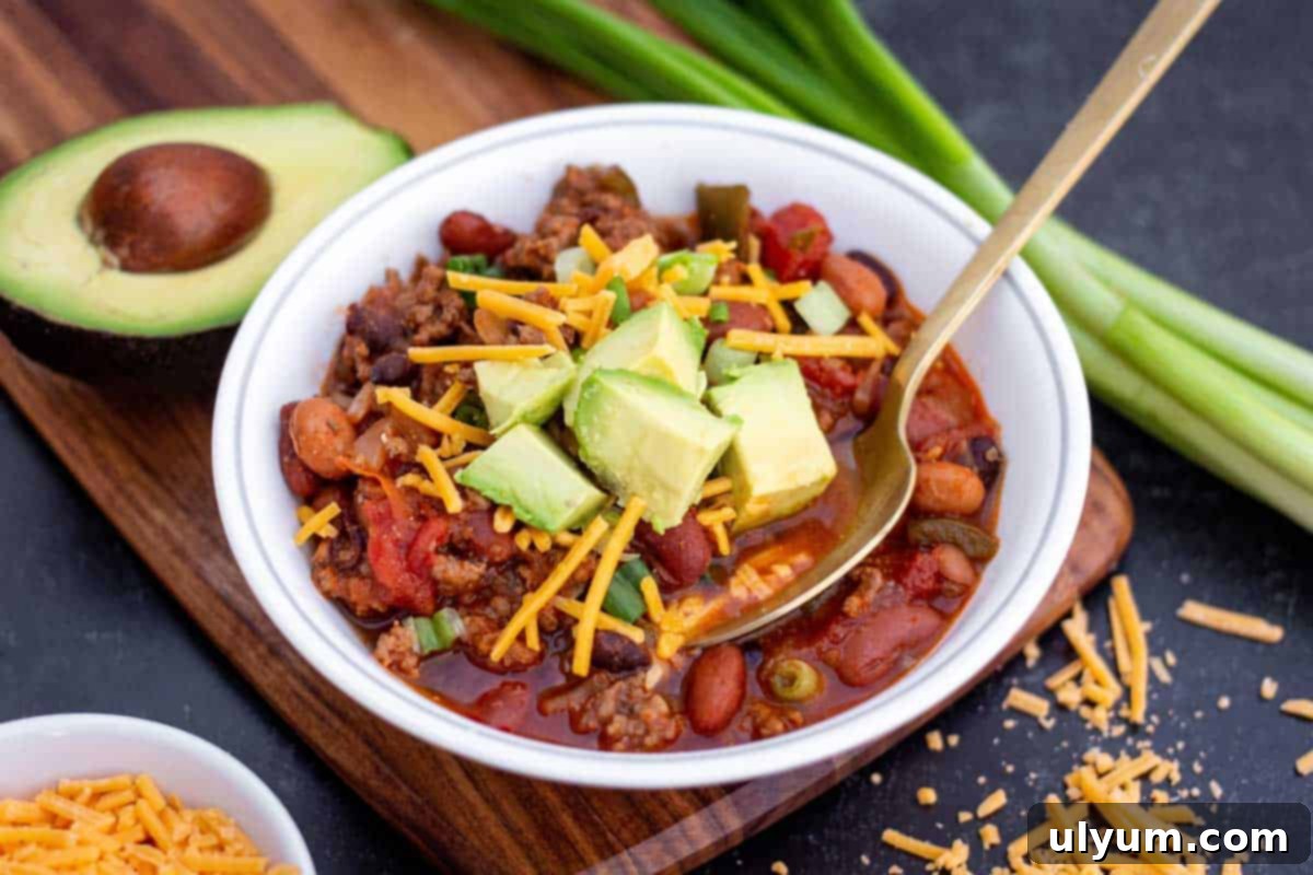 The Unexpected Ease of Shortcut Cooking: Reclaiming Meal Planning 4 Small bowl of ground beef and sausage chili with shredded cheddar and diced avocado on top.