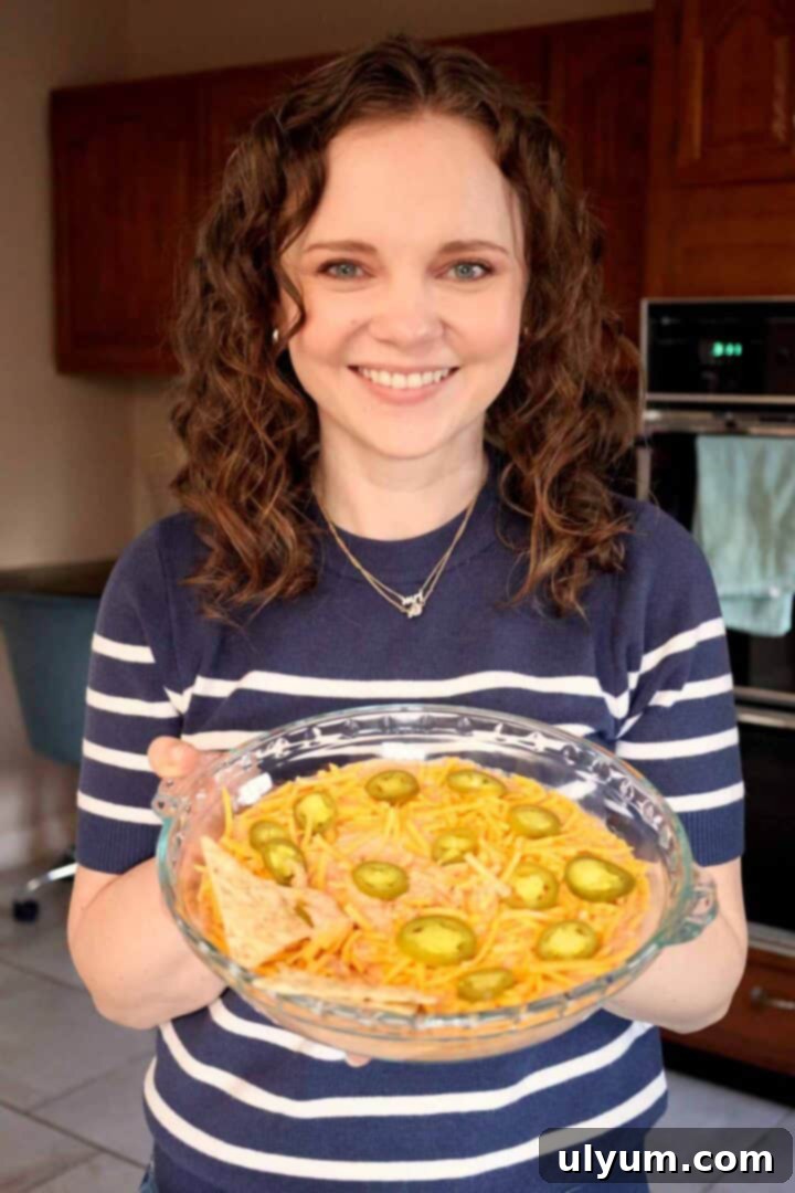 Kelsey Smith holding a glass pie dish filled with creamy salsa dip.